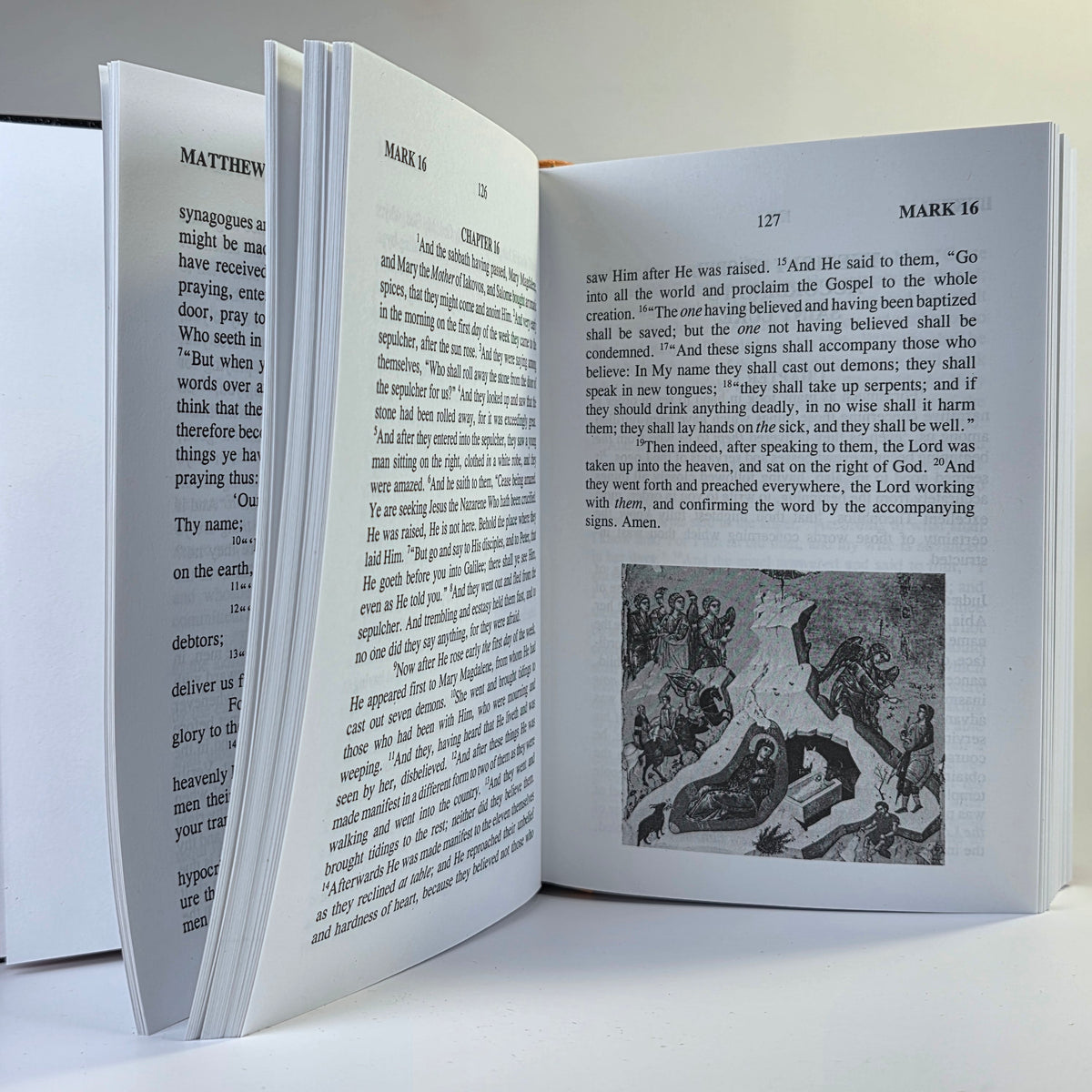 Open book with text and a black and white illustration on a white background